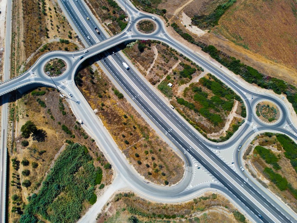 Trevo com duas rotatórias sobre uma rodovia de pista dupla, visto de cima