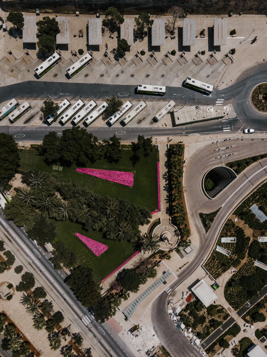 Terminal de ônibus visto de cima, com os ônibus parados nas baias em dente de serra, os abrigos da plataforma e a pista de circulação