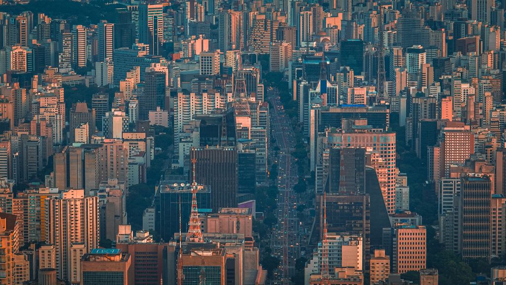 Avenida entre edifícios altos, vista do alto ao entardecer