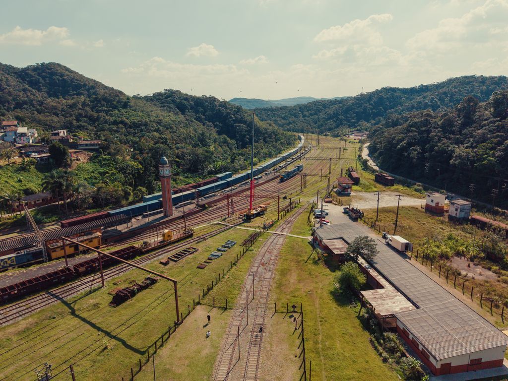 Pátio ferroviário de Paranapiacaba (SP) visto do alto, com vagões de carga e a serra ao fundo