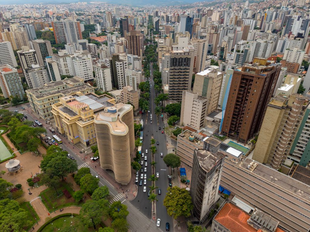Cidade vista do alto, com uma avenida arborizada de canteiro central entre os prédios
